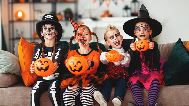 happy Halloween! a group of children in suits and with pumpkins in home